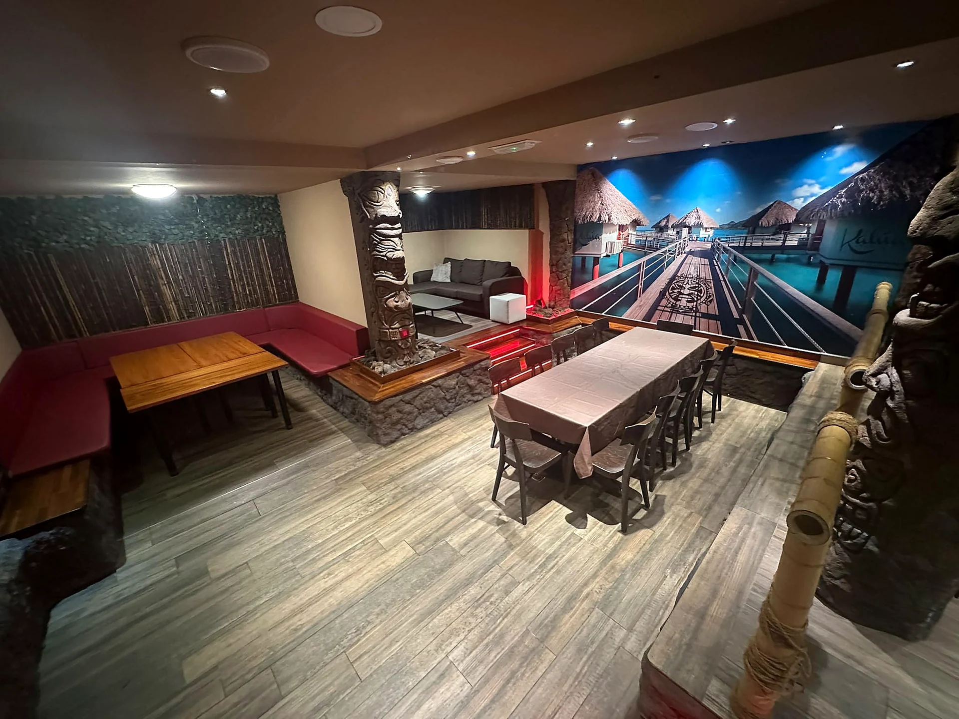 Sala VIP de Tiki Burger Blanes con mesas, sofá y decoración tropical